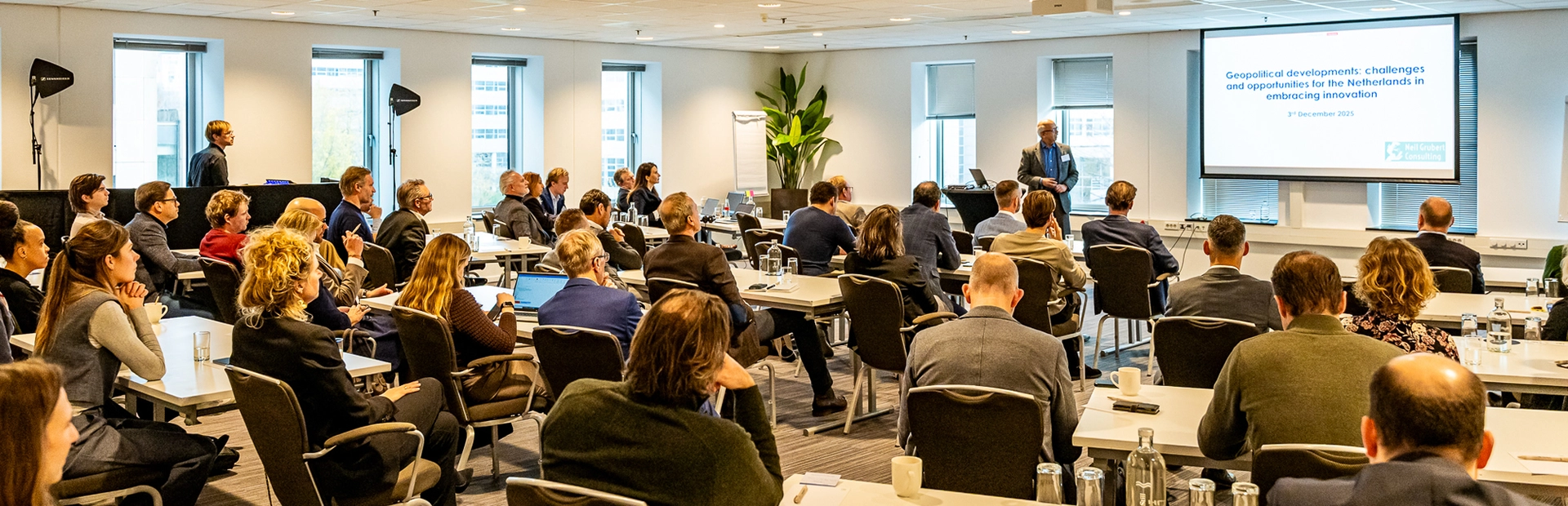 Groep professionals volgt een presentatie in een zaal